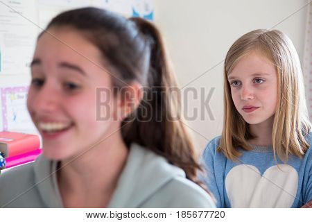 Young Girl Staring At Disliked Friend From Behind