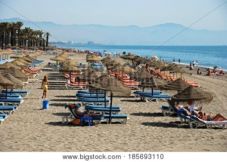 TORREMOLINOS, SPAIN - SEPTEMBER 3, 2008 - Tourists relaxing on the beach with views towards the mountains Torremolinos Malaga Province Andalusia Spain Western Europe, September 3, 2008.