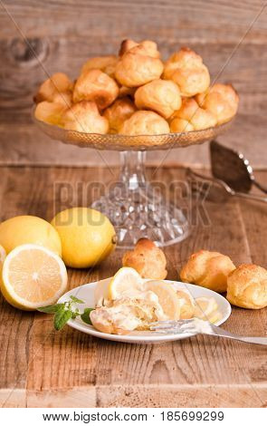 Lemon Profiteroles with custard cream on white dish.