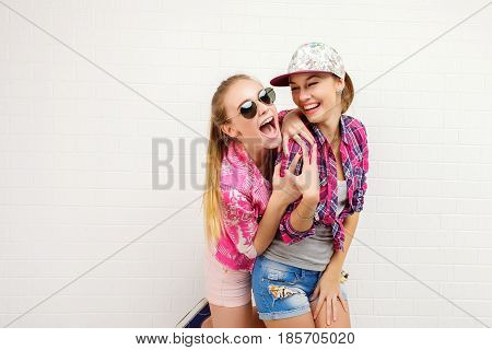 Fashion portrait of two friends posing. modern lifestyle. two stylish sexy hipster girls best friends ready for party. Two young girl friends standing together and having fun.