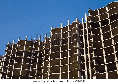 Unfinished cement building at a construction site. New multi-storey building. Construction activity of a very tall skyscraper intended for use as an office building.