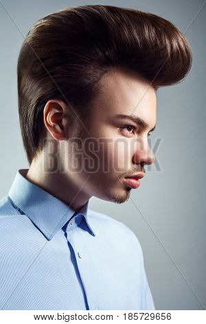 Side view of young man with retro classic pompadour hairstyle. studio shot.