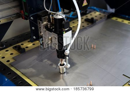 Compact stud welding head, metal processing background. Fully automatic welding process on steel or aluminium material