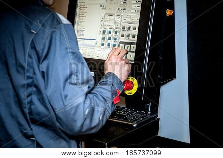 Working place of CNC operator, man touching lcd screen of the machine
