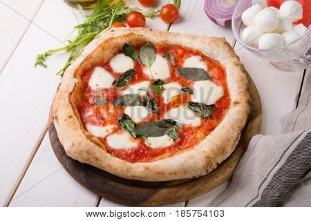 Whole neapolitan pizza served on wooden board