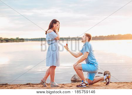 Marriage proposal on sunset . young man makes a proposal of betrothal to his girlfriend on the beach