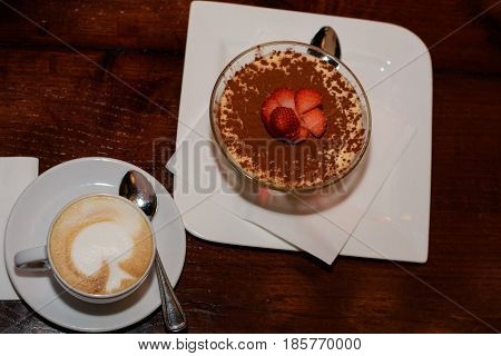 Delicious coffee with milk froth and sweet dessert
