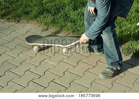 inexperienced kid learns to ride a skateboard. newbie
