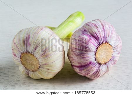A whole head of garlic close-up on a wooden surface. Ingredient for cooking. Macro