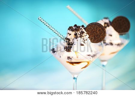 Vanilla sundae ice cream with chocolate sauce and cookies by the pool