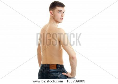 young serious guy worth his back to the camera and looking directly isolated on white background