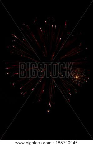 festive single explosions of fireworks in the dark sky