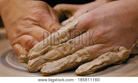 Potter is making clay pot bowl or vase ceramics porcelain on the potter's wheel. Creating pottery art and handicraft modelling creation.