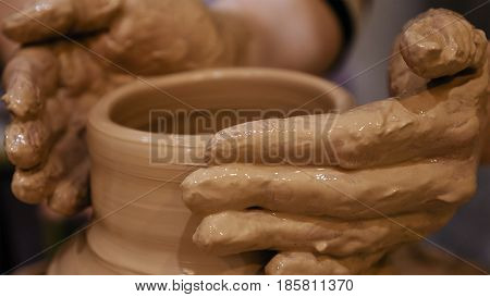 Potter is making clay pot bowl or vase ceramics porcelain on the potter's wheel. Creating pottery art and handicraft modelling creation.