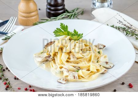 Fettuccine with white mushrooms on white plate