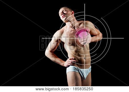 heartache. man suffers from heartache standing over black background A guy with bare body and muscular torso in white pants. Concept with Healthcare And Medicine.