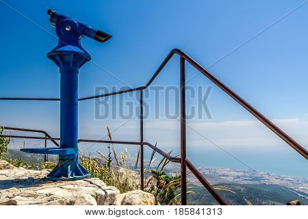 blue binoculars and a view of the coast and sea