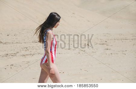 Patriot beautiful woman walking on the beach in July.