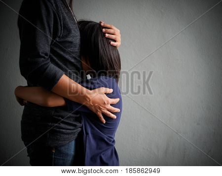 sad son hugging his mother at home. Concept of couple family is in sorrow.
