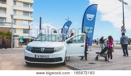 Sables d Olonne France - May 07 2017 : Dacia Tour 2017 is a commercial operation organized by the car builder in order to present its cars throughout France - A young man watching a car
