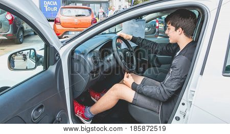 Sables d Olonne France - May 07 2017 : Dacia Tour 2017 is a commercial operation organized by the car builder in order to present its cars throughout France - A young man watching a car