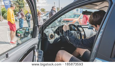 Sables d Olonne France - May 07 2017 : Dacia Tour 2017 is a commercial operation organized by the car builder in order to present its cars throughout France - A young man watching a car