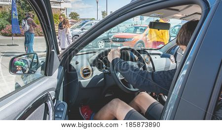 Sables d Olonne France - May 07 2017 : Dacia Tour 2017 is a commercial operation organized by the car builder in order to present its cars throughout France - A young man watching a car