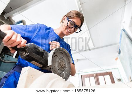 Stonemason cutting marble stone with angle sander and diamond disc