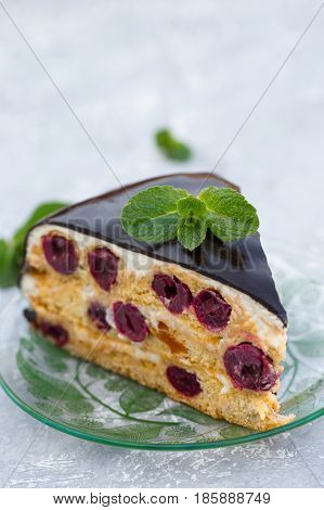 Cake with cherry, cream and chocolate icing