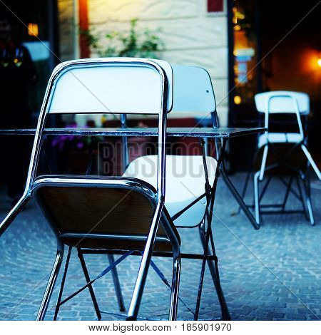 an empty couple of tables with chairs in a bistrot near the city centre of rome