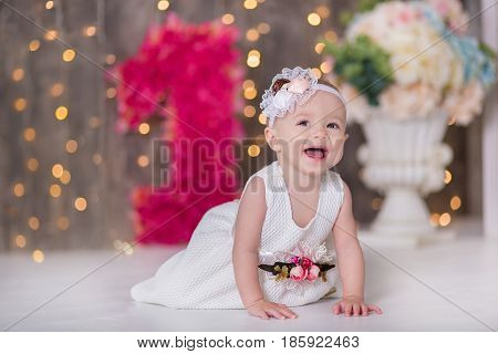 Cute baby girl 1-2 year old sitting on floor with pink balloons in room over white. Isolated. Birthday party. Celebration. Happy birthday baby, Little girl with group ball. Play room