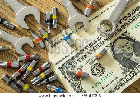 Hand tools and money on wooden table