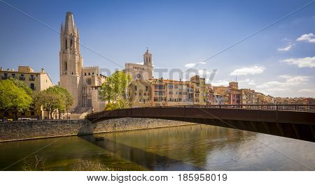 Sant Feliu bridge and Sant Feliu church in Girona, Catalonia, Spain. Colorful houses near the river. Long shutterspeed shot.