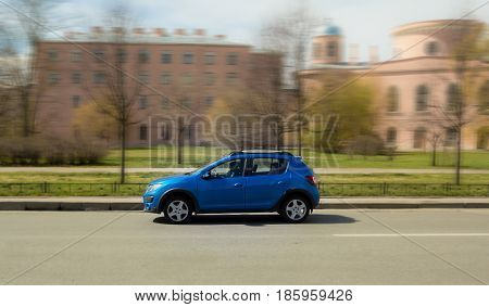 blue minicar on city streets, high speed