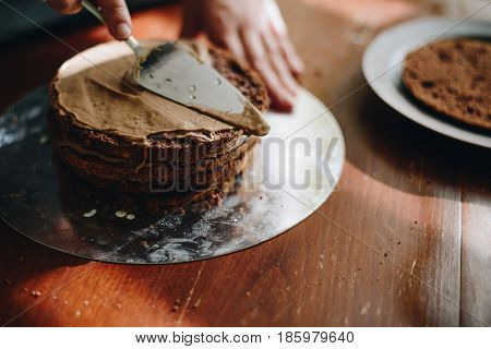 woman hands makeing cake on wooden background