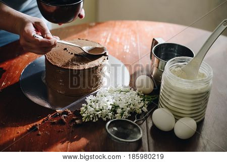 woman hands makeing cake on wooden background
