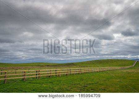 Long neverending wooden fence in the irish countryside, Ireland