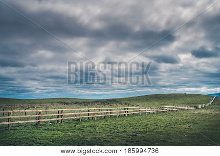 Long neverending wooden fence in the irish countryside, Ireland