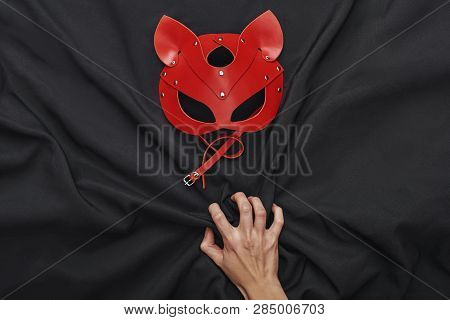 Sexual Pleasure. Top View Of Hand Touching Black Silk Fabric And Red Bdsm Leather Mask
