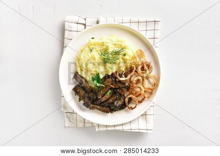 Roasted Beef Liver With Mashed Potatoes And Fried Onion Rings On White Plate Over Stone Background W