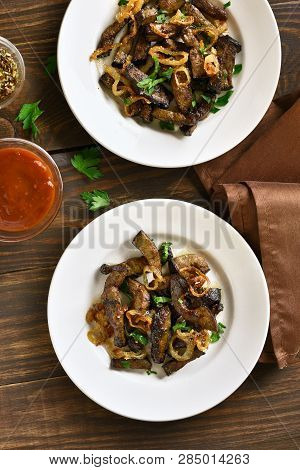 Sliced Fried Beef Liver With Onion On Plate Over Wooden Background. Pieces Cooked Liver (offal) From