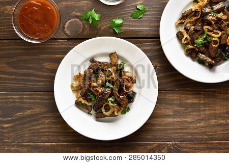 Roasted Beef Liver With Onion On Plate Over Wooden Background. Pieces Cooked Liver (offal) From Beef