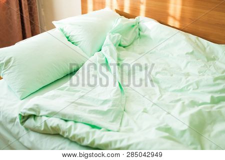 Minty Green Bedding On The Bed At The Early Sunny Morning. Wake-up Tipe.