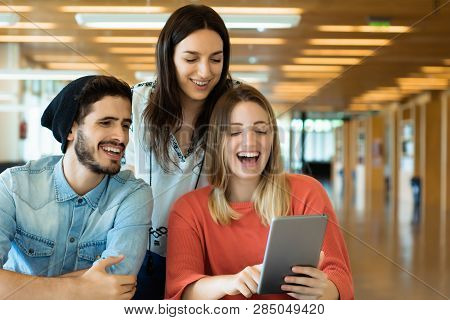 University Students Using Digital Tablet In University Library.