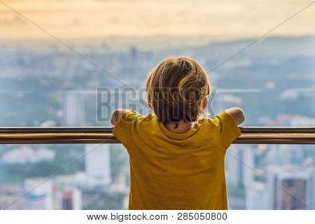 Little Boy Looks At Kuala Lumpur Cityscape. Panoramic View Of Kuala Lumpur City Skyline Evening At S
