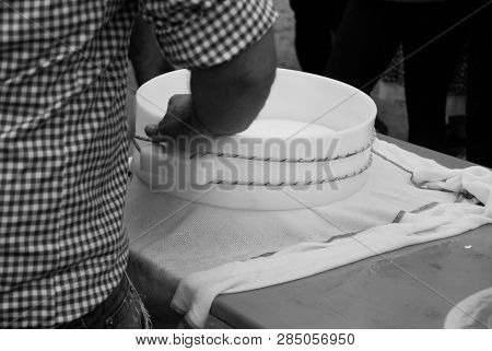 Man Using A Circular Mold To Shape The Cheese