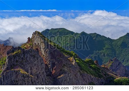 Panoramic View Of Mountain Peaks Against Clouds Below Horizon And Clear Blue Sky On Sunny Day. View 