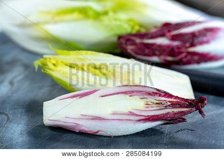 Group Of Fresh Green Belgian Endive Or Chicory And Red Radicchio Vegetables, Also Known As Witlof Sa
