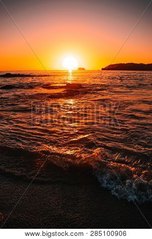 Orange Teal Sunset On A Beautiful Beach. Beautiful Vivid Sunset Over Beach With The Water Vivid. A B