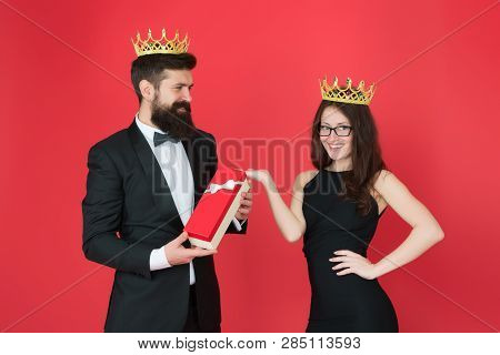 Queen Of His Heart. Man Bearded King In Tuxedo Golden Crown Giving Gift Box To Woman Elegant Dress. 
